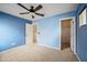 Blue bedroom with neutral carpet, ceiling fan, and a walk-in closet at 4587 E Silverbell Rd, San Tan Valley, AZ 85143