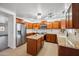 Modern kitchen featuring granite countertops, stainless steel appliances, wooden cabinetry, and tile floors at 4587 E Silverbell Rd, San Tan Valley, AZ 85143