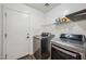 Convenient laundry room with modern appliances and shelving for storage at 4587 E Silverbell Rd, San Tan Valley, AZ 85143