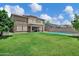 Lush green backyard with well-maintained lawn and view of the home and a swimming pool at 4647 E County Down Dr, Chandler, AZ 85249