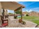 Covered patio and fenced in backyard with a view of the pool and well-manicured lawn at 5220 W Desert Ln, Laveen, AZ 85339
