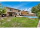 Large backyard with grassy lawn, white fence, covered patio, and view of the pool at 5220 W Desert Ln, Laveen, AZ 85339