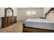 Bedroom with a wooden dresser with mirror, bed frame, and window with blinds at 5220 W Desert Ln, Laveen, AZ 85339