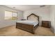 Bedroom with tile floors, a window, and a wooden headboard with matching nightstands at 5220 W Desert Ln, Laveen, AZ 85339