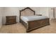 This bedroom features a wooden bed frame, matching bedside tables, and tile flooring at 5220 W Desert Ln, Laveen, AZ 85339