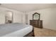 This bedroom features tile flooring, a dresser with mirror, and access to the bathroom and hallway at 5220 W Desert Ln, Laveen, AZ 85339
