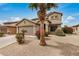 Two story home with desert landscaping, a large palm tree, and two car garage at 5220 W Desert Ln, Laveen, AZ 85339