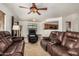 Open-concept living room featuring tile floors and neutral paint, filled with leather furniture at 5220 W Desert Ln, Laveen, AZ 85339