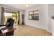 Bright living room with a sliding glass door, window, and neutral walls and flooring at 5220 W Desert Ln, Laveen, AZ 85339