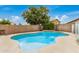 Inviting backyard pool with a charming waterfall feature, surrounded by a brick wall and lush greenery, creating a private oasis at 5220 W Desert Ln, Laveen, AZ 85339