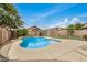 Refreshing backyard pool surrounded by a large concrete patio, white fence, and lush trees at 5220 W Desert Ln, Laveen, AZ 85339