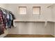 This walk-in closet includes installed shelving, racks and two windows at 5220 W Desert Ln, Laveen, AZ 85339