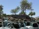 Beautiful entrance to The Bridges at Gilbert with a stone sign, landscaping, and rock waterfalls at 5420 S Mariposa Dr, Gilbert, AZ 85298