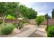 Serene backyard with lush greenery, mature trees, a brick-paved walkway, and a storage shed for convenience at 5451 W Folley St, Chandler, AZ 85226