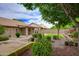 Beautifully landscaped backyard featuring mature trees, lush plantings, paved walkways, and a covered patio at 5451 W Folley St, Chandler, AZ 85226