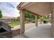 Inviting covered patio with stone columns, an outdoor grill, and a view of the beautifully landscaped backyard at 5451 W Folley St, Chandler, AZ 85226