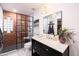 Renovated bathroom featuring a glass enclosed shower with brick accents, modern vanity, and stylish lighting at 546 W Cambridge Ave, Phoenix, AZ 85003
