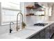 Well-lit kitchen featuring a white farmhouse sink, stylish faucet, and gray cabinets at 546 W Cambridge Ave, Phoenix, AZ 85003