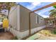 Exterior view of the mobile home showing siding, landscaping, carport frame, and an AC unit at 5601 W Missouri Ave # 254, Glendale, AZ 85301