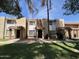 Exterior view of townhome featuring a covered entryway, neutral toned facade, well-maintained lawn and mature trees at 7126 N 19Th Ave # 108, Phoenix, AZ 85021
