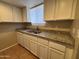 Functional kitchen showcasing granite countertops, white cabinets, stainless steel sink, and modern appliances at 7126 N 19Th Ave # 108, Phoenix, AZ 85021