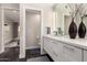 Bright bathroom features dual sinks with white cabinetry, a large mirror, and a separate toilet room at 7222 E Gainey Ranch Rd # 140, Scottsdale, AZ 85258
