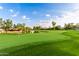 Scenic golf course view featuring a tranquil pond and lush green fairway under a partly cloudy blue sky at 7222 E Gainey Ranch Rd # 140, Scottsdale, AZ 85258