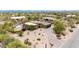 Expansive aerial view of a home with solar panels, landscaped grounds, and a inviting pool in the Arizona desert at 8255 E Yearling Rd, Scottsdale, AZ 85255