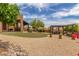 Expansive backyard with a covered patio, outdoor kitchen, grassy area, and gravel landscaping at 8255 E Yearling Rd, Scottsdale, AZ 85255