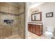 Bathroom with a glass shower and vanity with dark wood cabinets and marble countertops at 8255 E Yearling Rd, Scottsdale, AZ 85255