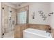 Elegant bathroom with a walk-in shower featuring decorative tiles, a soaking tub, and stylish fixtures at 8255 E Yearling Rd, Scottsdale, AZ 85255