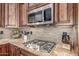 Close-up of the modern kitchen with stainless steel appliances, granite countertops, and stylish backsplash at 8255 E Yearling Rd, Scottsdale, AZ 85255