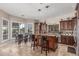 Bright kitchen featuring dark wood cabinetry, a granite island with bar seating, and stainless steel appliances at 8255 E Yearling Rd, Scottsdale, AZ 85255