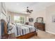 Bright main bedroom with a cozy seating area, ceiling fan, and large windows overlooking the backyard at 8255 E Yearling Rd, Scottsdale, AZ 85255