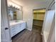 Bright bathroom featuring a modern vanity with a marble countertop and an open walk-in closet at 8514 S 49Th Dr, Laveen, AZ 85339