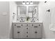 Double vanity bathroom with modern fixtures, and a mirror with stylish accent wall at 8714 E Plaza Ave, Scottsdale, AZ 85250