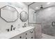 Modern bathroom featuring a double vanity, dual mirrors and a glass enclosed shower at 8714 E Plaza Ave, Scottsdale, AZ 85250