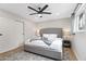 Bright bedroom featuring a tufted headboard, ceiling fan, and natural light from the window at 8714 E Plaza Ave, Scottsdale, AZ 85250