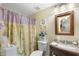 Well-lit bathroom with floral shower curtain, decorative plates, and vanity providing a functional space at 930 N Mesa Dr # 1045, Mesa, AZ 85201