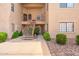 View of the condo exterior with staircase, desert landscaping, and a glimpse of the inviting front door at 930 N Mesa Dr # 1045, Mesa, AZ 85201