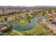 This aerial shot features a neighborhood golf course, trees, and a water feature at 9702 E Naranja Ave, Mesa, AZ 85209