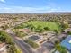 An aerial view of a neighborhood park featuring a playground, sports field, and a basketball court at 9702 E Naranja Ave, Mesa, AZ 85209
