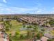 This aerial shot showcases a community golf course, lush landscaping, and inviting ponds at 9702 E Naranja Ave, Mesa, AZ 85209