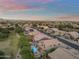 Stunning aerial view of a suburban neighborhood with swimming pools and well-manicured landscapes at sunset at 9702 E Naranja Ave, Mesa, AZ 85209
