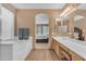 Well lit bathroom with soaking tub, double sinks and view into the bedroom at 9702 E Naranja Ave, Mesa, AZ 85209