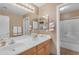 Bathroom featuring double sinks, a large mirror, and a shower-tub combination at 9702 E Naranja Ave, Mesa, AZ 85209