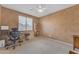 Cozy bedroom featuring neutral tones, a ceiling fan, and a window with blinds, furnished with a work space at 9702 E Naranja Ave, Mesa, AZ 85209
