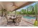 Charming covered patio with comfortable seating, a ceiling fan, and a view of the refreshing pool at 9702 E Naranja Ave, Mesa, AZ 85209