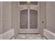The front door has decorative iron scroll work with neutral colors at 9702 E Naranja Ave, Mesa, AZ 85209