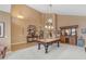 Spacious game room with a pool table, high ceilings, and a decorative chandelier for entertaining at 9702 E Naranja Ave, Mesa, AZ 85209